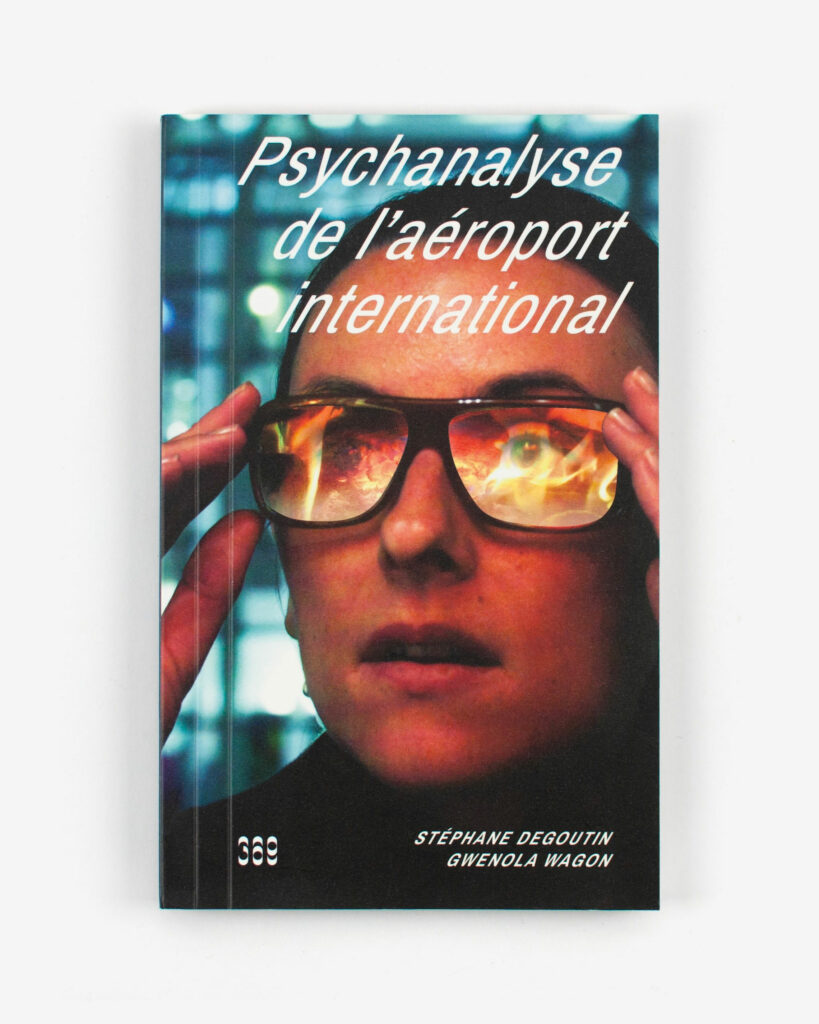 Couverture de Psychanalyse de l'aéroport international. Le portrait d'un homme avec des lunettes, le reflet révèle des flammes.